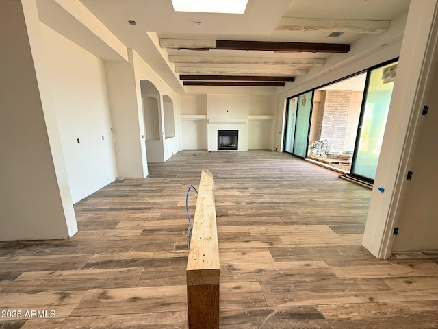 hall with beamed ceiling and wood finished floors