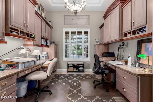 office space with a chandelier, built in study area, and baseboards