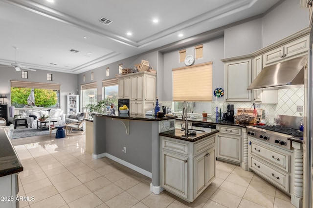 kitchen with visible vents, cream cabinetry, under cabinet range hood, open floor plan, and stainless steel gas cooktop