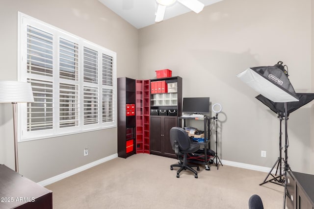 carpeted home office with a ceiling fan and baseboards