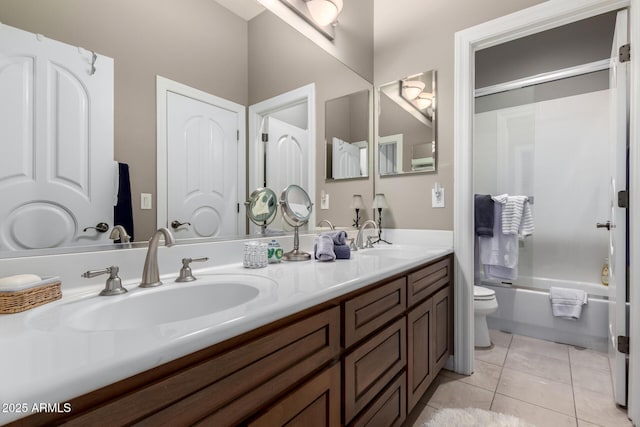 bathroom featuring a sink, toilet, double vanity, and tile patterned floors