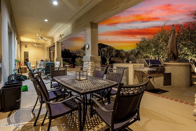 view of patio with outdoor dining space, a grill, exterior kitchen, and a ceiling fan