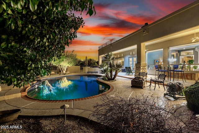 outdoor pool featuring a patio area and a fire pit