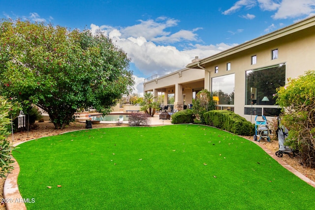 view of yard with a balcony and a patio area