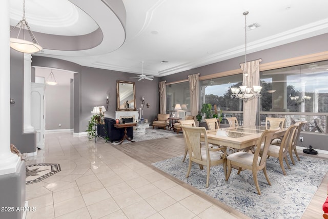 tiled dining area with visible vents, baseboards, and ceiling fan with notable chandelier