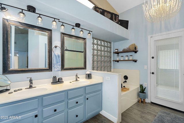 10226 W Country Club Trl, Peoria, AZ 85383 - full bath with double vanity, a garden tub, wood finished floors, a chandelier, and high vaulted ceiling