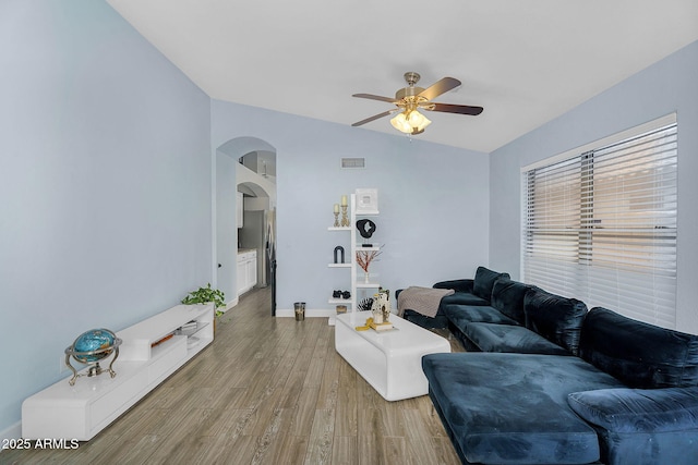 10226 W Country Club Trl, Peoria, AZ 85383 - living area featuring arched walkways, ceiling fan, light wood-style flooring, and baseboards