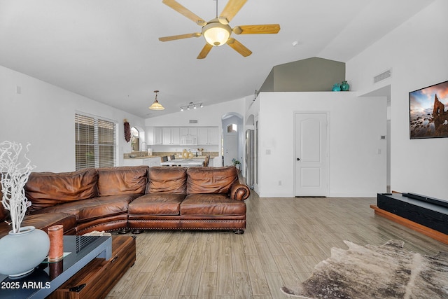 10226 W Country Club Trl, Peoria, AZ 85383 - living room with arched walkways, a ceiling fan, light wood-style flooring, high vaulted ceiling, and baseboards
