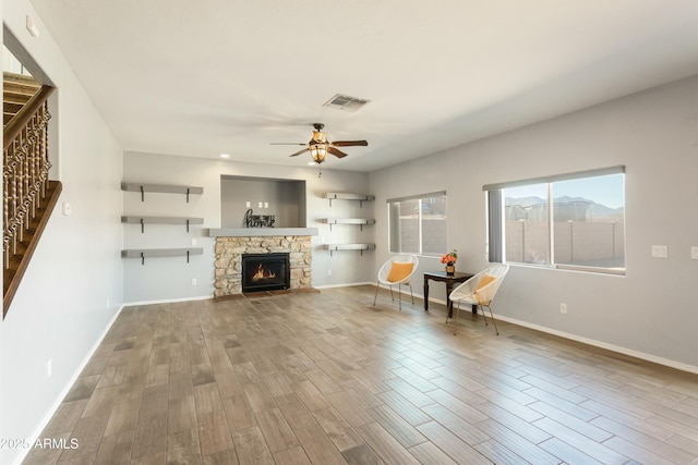 unfurnished living room with ceiling fan and a fireplace