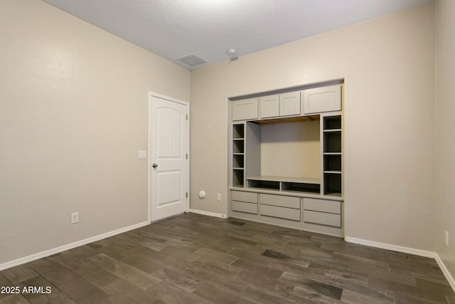 unfurnished bedroom with dark hardwood / wood-style flooring and a closet