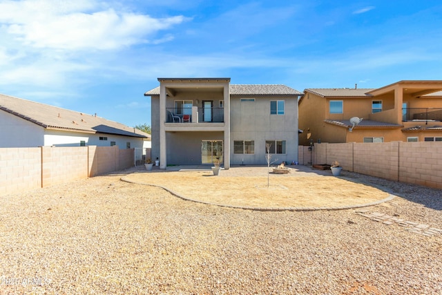 back of house featuring a balcony and an outdoor fire pit