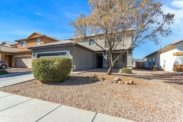 view of front of house with a garage and central AC unit