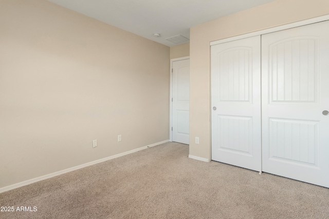 unfurnished bedroom featuring light carpet and a closet