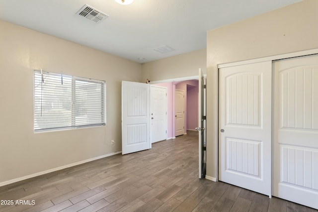 unfurnished bedroom with a closet and light wood-type flooring