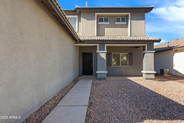 doorway to property with central AC unit and a patio area