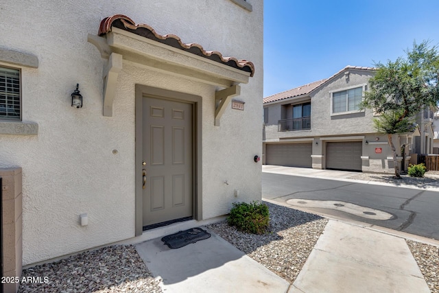 2941 E Darrow St, Phoenix, AZ 85042 - doorway to property with stucco siding, a garage, concrete driveway, and a tiled roof
