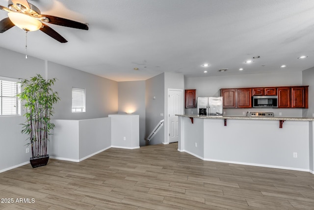 2941 E Darrow St, Phoenix, AZ 85042 - kitchen featuring stainless steel appliances, a kitchen breakfast bar, a ceiling fan, recessed lighting, and light wood-style flooring