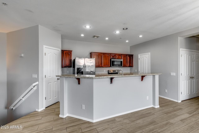 2941 E Darrow St, Phoenix, AZ 85042 - kitchen with stainless steel fridge, light wood-style flooring, recessed lighting, a kitchen bar, and range