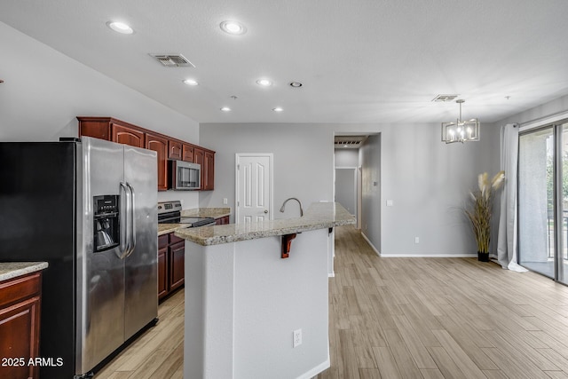 2941 E Darrow St, Phoenix, AZ 85042 - kitchen featuring stainless steel appliances, a chandelier, light wood-type flooring, recessed lighting, and light stone countertops