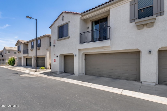 2941 E Darrow St, Phoenix, AZ 85042 - view of front of house featuring stucco siding, a garage, a tile roof, a balcony, and a residential view