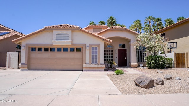 10952 S Desert Lake Dr, Goodyear, AZ 85338 - mediterranean / spanish-style home featuring a tiled roof, fence, concrete driveway, an attached garage, and stucco siding