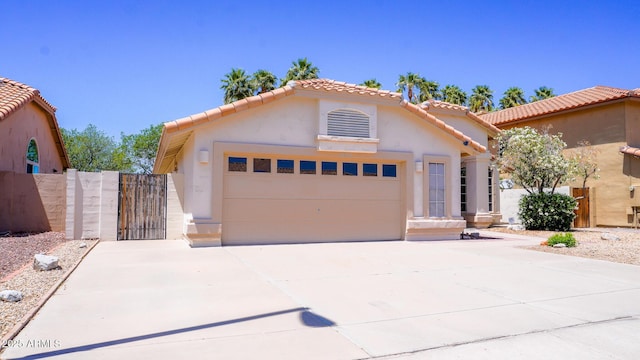10952 S Desert Lake Dr, Goodyear, AZ 85338 - view of front of home featuring a tiled roof, a gate, a garage, concrete driveway, and stucco siding