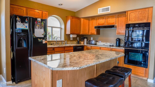 10952 S Desert Lake Dr, Goodyear, AZ 85338 - kitchen featuring visible vents, vaulted ceiling, a sink, black appliances, and under cabinet range hood