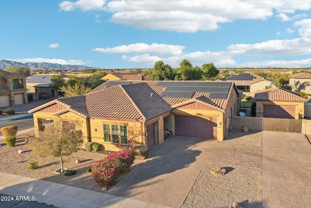 view of front of property with a mountain view, a garage, and solar panels