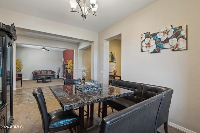 carpeted dining space with ceiling fan with notable chandelier