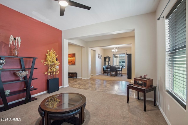 interior space with light colored carpet and ceiling fan with notable chandelier