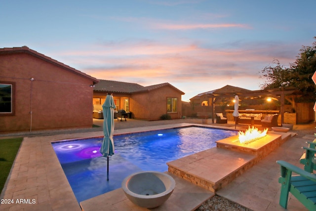 pool at dusk with a patio area, a hot tub, and a fire pit