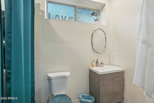 bathroom featuring plenty of natural light, toilet, and vanity