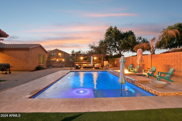 pool at dusk featuring a patio area and area for grilling