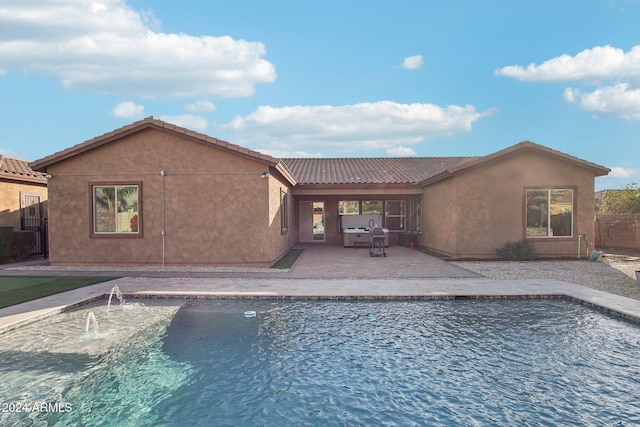 view of swimming pool with pool water feature and a patio