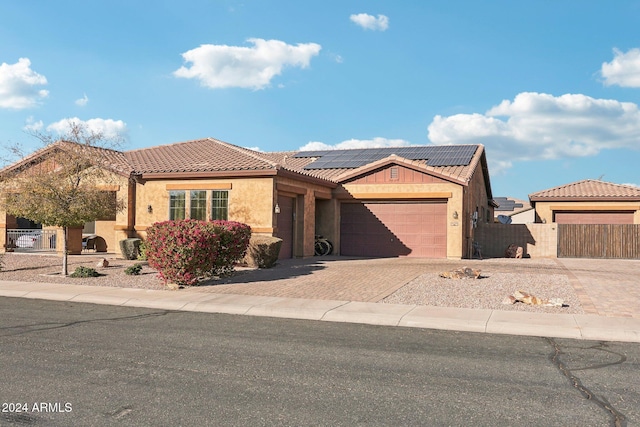 view of front of house featuring solar panels and a garage