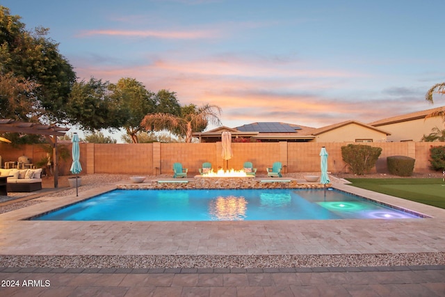 pool at dusk featuring a patio