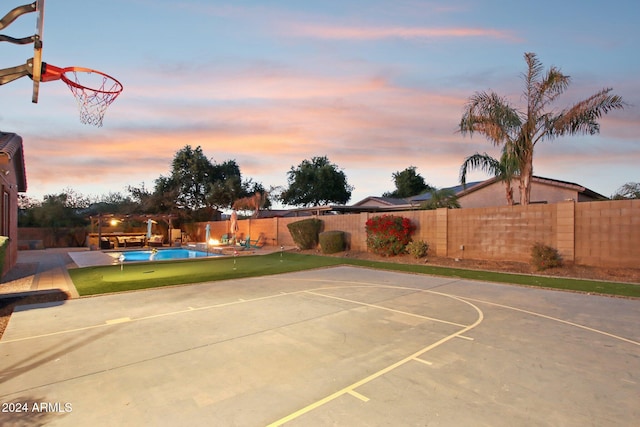 view of sport court featuring a fenced in pool