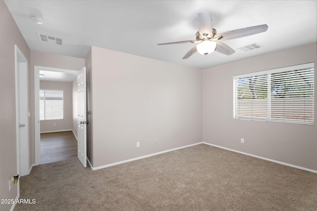 carpeted empty room with a ceiling fan, visible vents, and baseboards