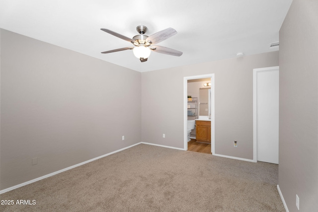 unfurnished bedroom featuring light colored carpet, visible vents, connected bathroom, ceiling fan, and baseboards