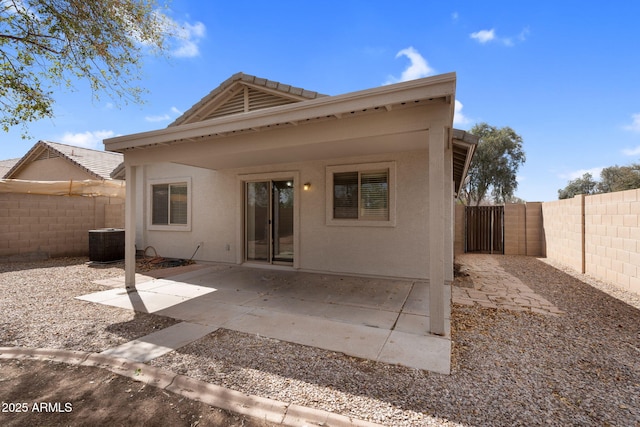 rear view of house with a patio, stucco siding, a fenced backyard, and central air condition unit