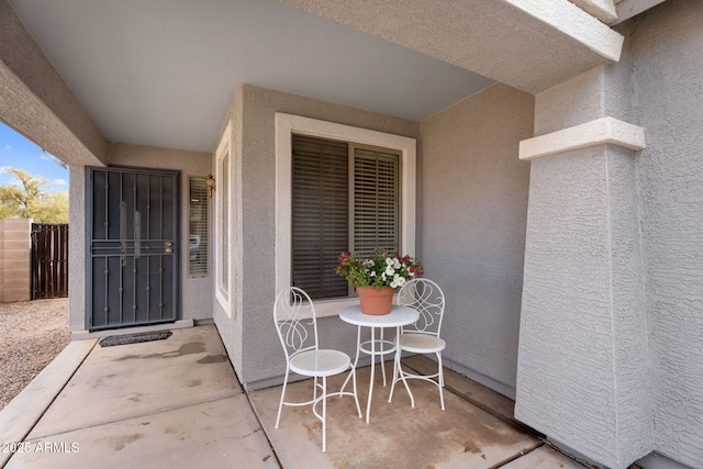 view of exterior entry with a patio and stucco siding