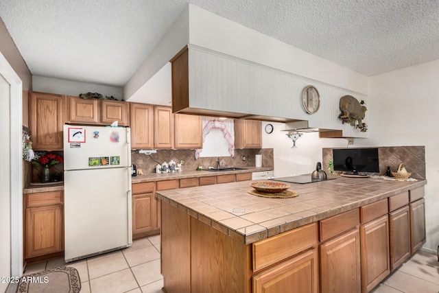 619 E Elaine St, Casa Grande, AZ 85122 - kitchen with backsplash, a textured ceiling, a sink, freestanding refrigerator, and light tile patterned flooring