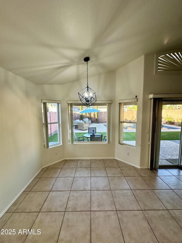 unfurnished dining area featuring light tile patterned flooring, plenty of natural light, baseboards, and a notable chandelier