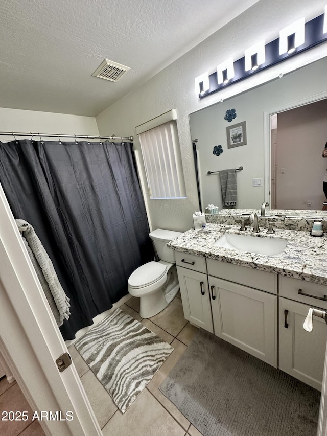 bathroom with tile patterned flooring, visible vents, toilet, vanity, and a textured ceiling