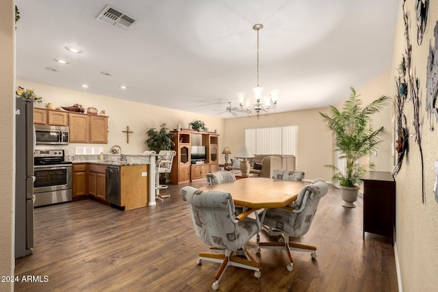 dining room featuring dark hardwood / wood-style floors, sink, and ceiling fan with notable chandelier