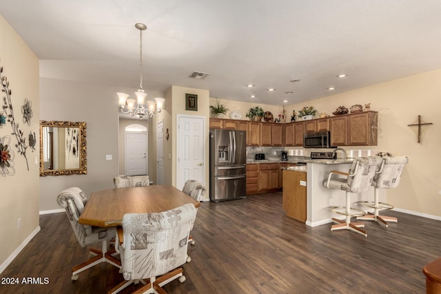 dining space featuring dark wood-type flooring and a chandelier