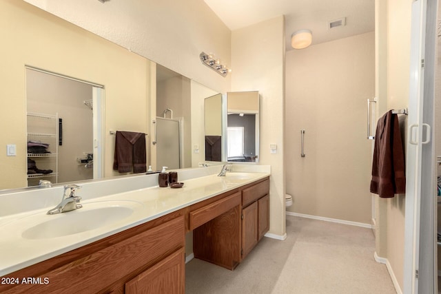 bathroom featuring a shower with door, vanity, and toilet