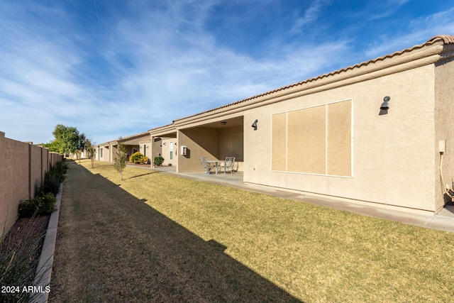 rear view of house featuring a patio area and a lawn