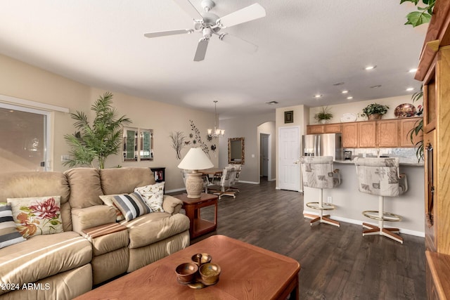 living room featuring ceiling fan with notable chandelier and dark wood-type flooring