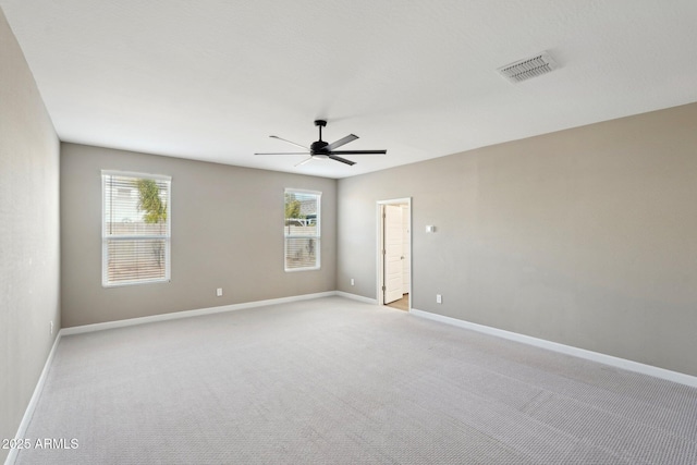 empty room featuring ceiling fan and light carpet